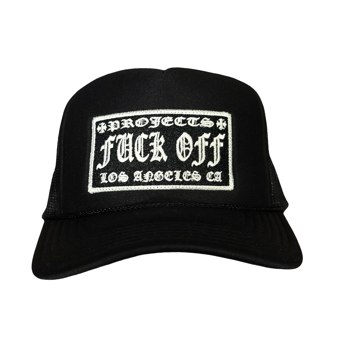 A black trucker hat with a white embroidered patch on the front that reads 'Projects Fuck Off Los Angeles CA'.