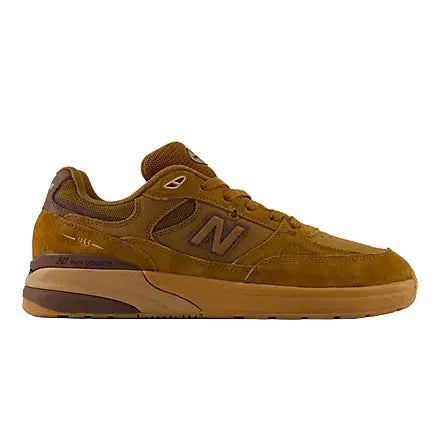 A New Balance sneaker in a monochromatic brown and tan colorway, featuring suede and mesh panels, a large 'N' logo on the side, and a thick gum sole, shown against a plain light gray background.
